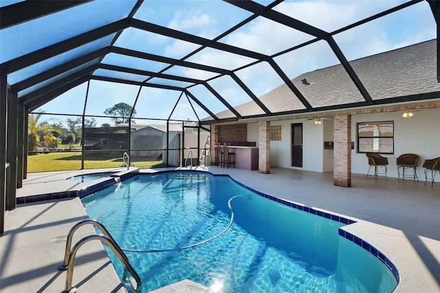 view of swimming pool with a bar, an in ground hot tub, a patio area, and glass enclosure