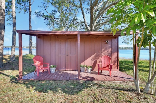 view of outbuilding featuring a water view and a lawn