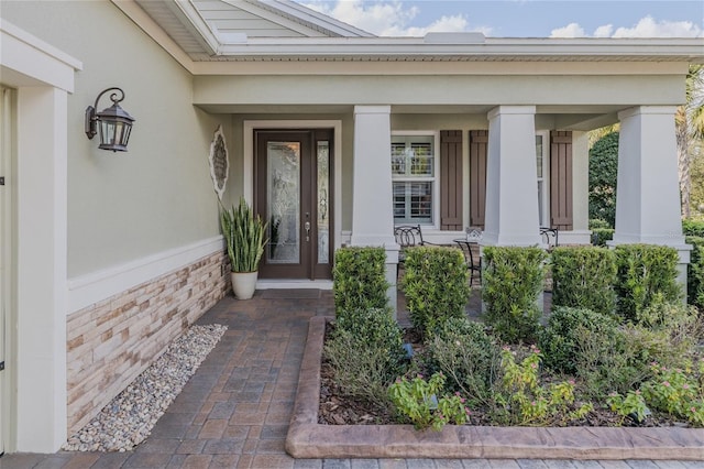 view of exterior entry featuring covered porch