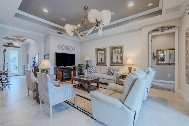 living room featuring light tile patterned floors, ornamental molding, and a raised ceiling