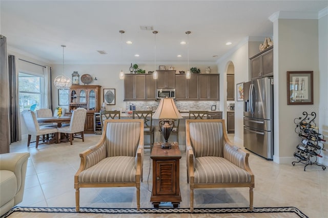 tiled living room featuring ornamental molding and a notable chandelier