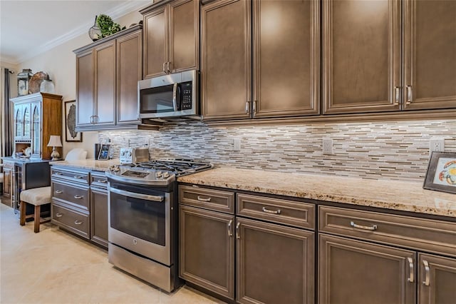 kitchen featuring tasteful backsplash, ornamental molding, stainless steel appliances, light stone countertops, and dark brown cabinets