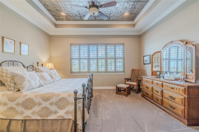 bedroom with crown molding, carpet flooring, a tray ceiling, and ceiling fan