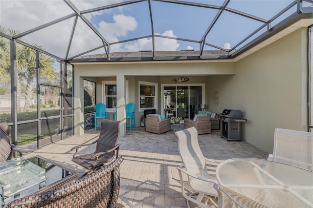 view of patio / terrace with a grill, outdoor lounge area, and glass enclosure