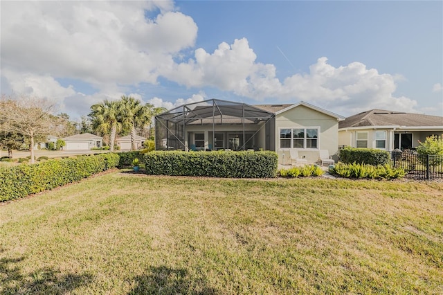 rear view of house with a yard and a lanai