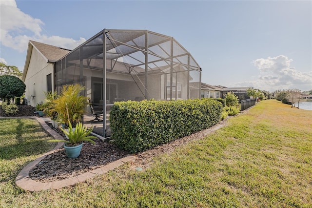 view of property exterior featuring glass enclosure and a lawn