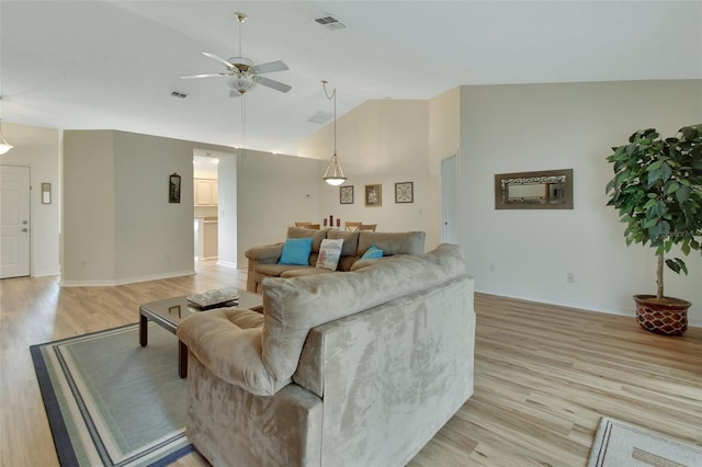 living room featuring ceiling fan, high vaulted ceiling, and light wood-type flooring