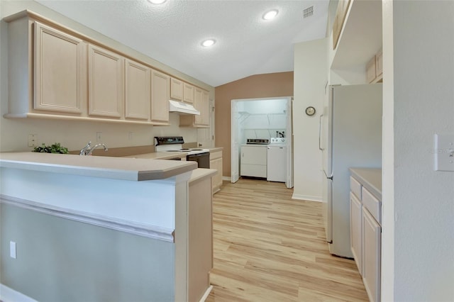 kitchen featuring washing machine and clothes dryer, vaulted ceiling, light hardwood / wood-style flooring, electric range, and white refrigerator