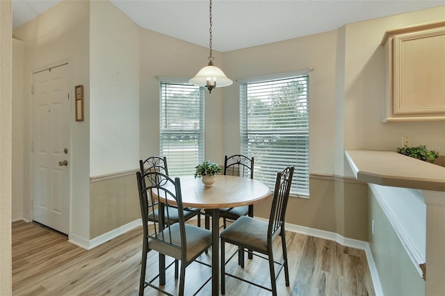 dining area featuring vaulted ceiling and light wood-type flooring