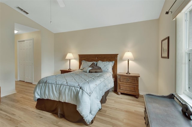 bedroom with ceiling fan, vaulted ceiling, and light wood-type flooring