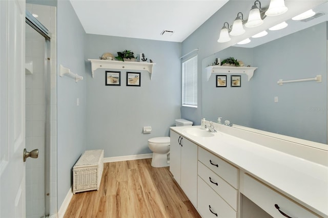 bathroom featuring vanity, hardwood / wood-style flooring, toilet, and walk in shower