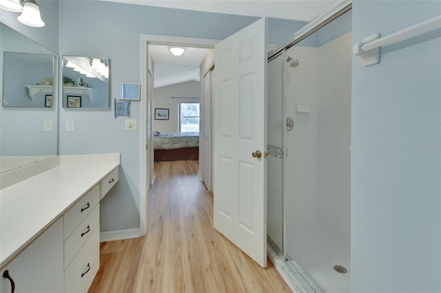 bathroom featuring vanity, hardwood / wood-style flooring, and a shower with shower door