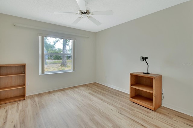 unfurnished room with ceiling fan, a textured ceiling, and light wood-type flooring