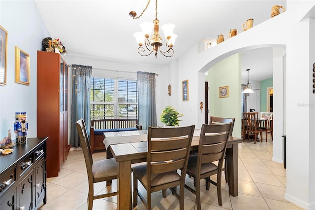 tiled dining space with a chandelier