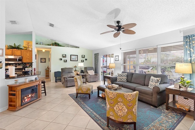 living room featuring light tile patterned flooring, vaulted ceiling, and a textured ceiling