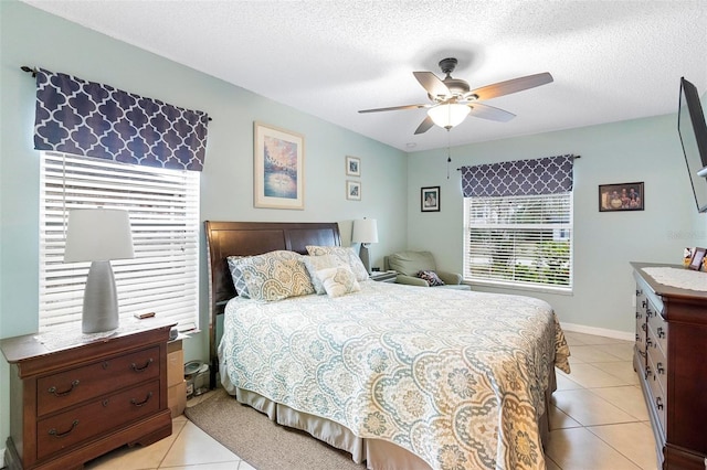 tiled bedroom with ceiling fan and a textured ceiling