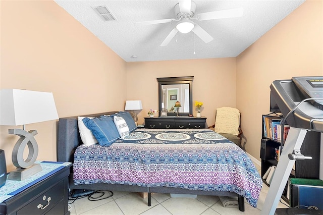 tiled bedroom with ceiling fan and a textured ceiling