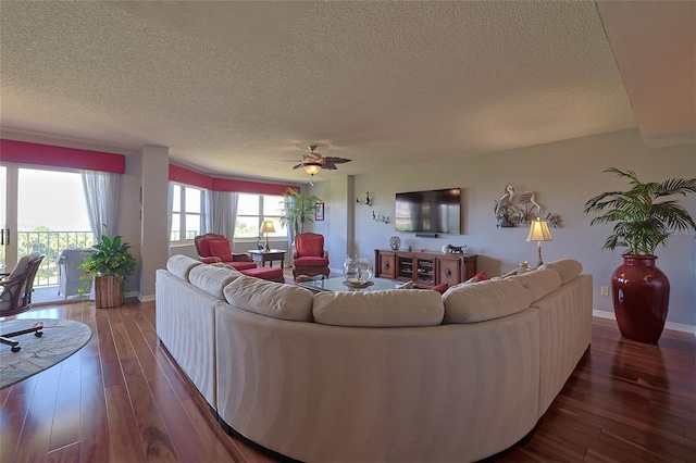 living room featuring hardwood / wood-style flooring, ceiling fan, and a textured ceiling