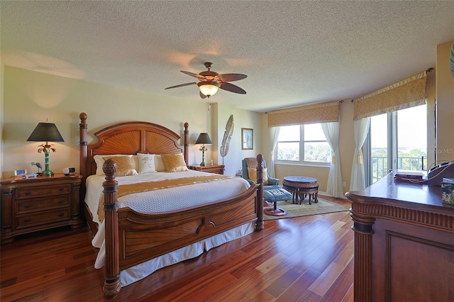 bedroom with ceiling fan, dark hardwood / wood-style floors, access to exterior, and a textured ceiling