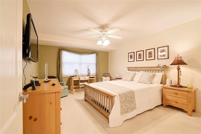 bedroom with light carpet, ceiling fan, and a textured ceiling