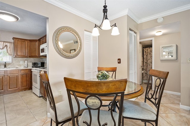 tiled dining area featuring crown molding and sink