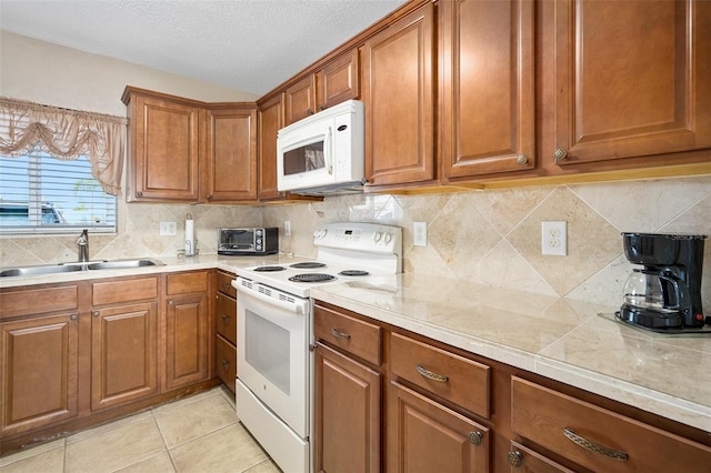 kitchen featuring light tile patterned flooring, sink, a textured ceiling, white appliances, and decorative backsplash