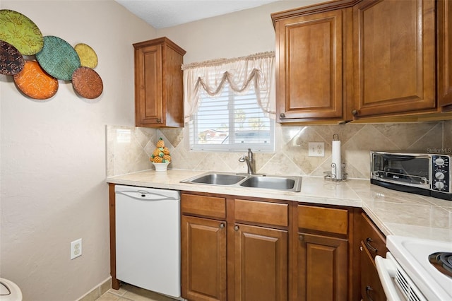 kitchen featuring dishwasher, sink, and decorative backsplash