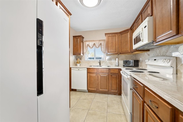 kitchen with light tile patterned flooring, sink, tasteful backsplash, a textured ceiling, and white appliances