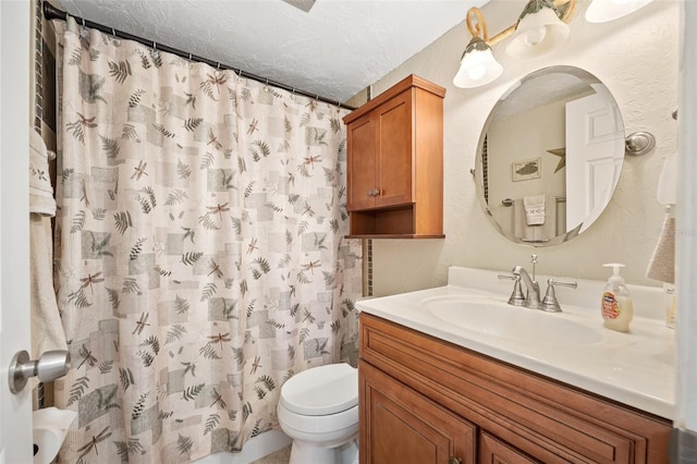 bathroom with vanity, curtained shower, toilet, and a textured ceiling