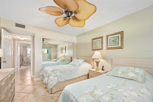 tiled bedroom featuring ceiling fan and a closet