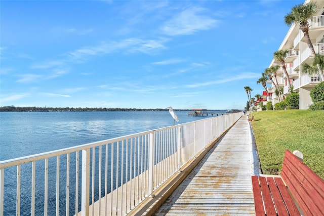 view of dock featuring a water view and a lawn