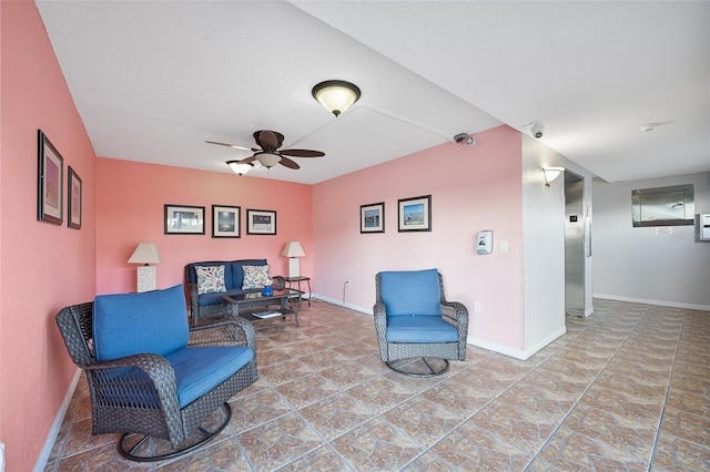 living area featuring ceiling fan and a textured ceiling