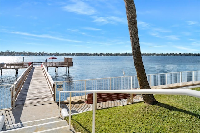 dock area with a water view and a lawn