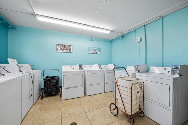 washroom with washing machine and dryer and light tile patterned flooring