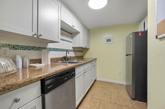 kitchen with white cabinetry, sink, backsplash, dark stone counters, and stainless steel appliances