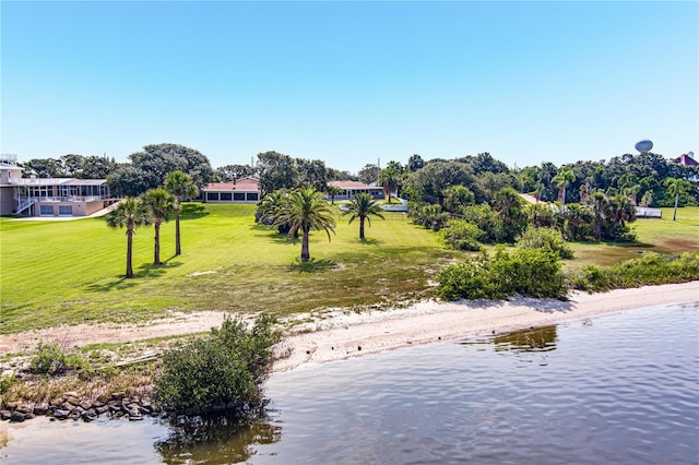 view of home's community with a water view and a lawn