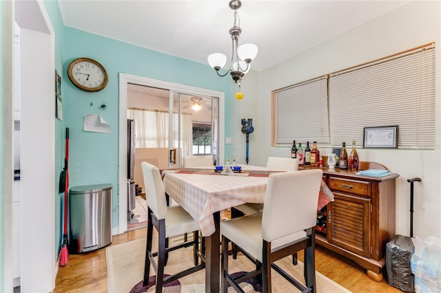 dining space with light wood finished floors and a chandelier