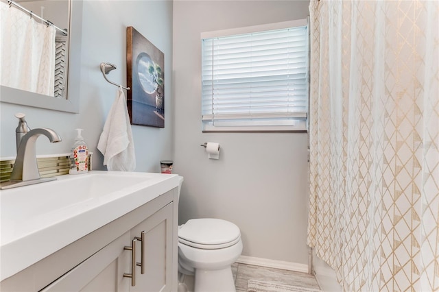 bathroom with baseboards, vanity, a shower with curtain, and toilet