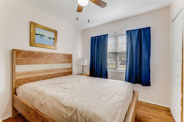 bedroom featuring ceiling fan, baseboards, and wood finished floors