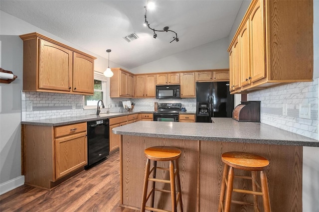 kitchen with sink, dark wood-type flooring, a kitchen breakfast bar, black appliances, and vaulted ceiling