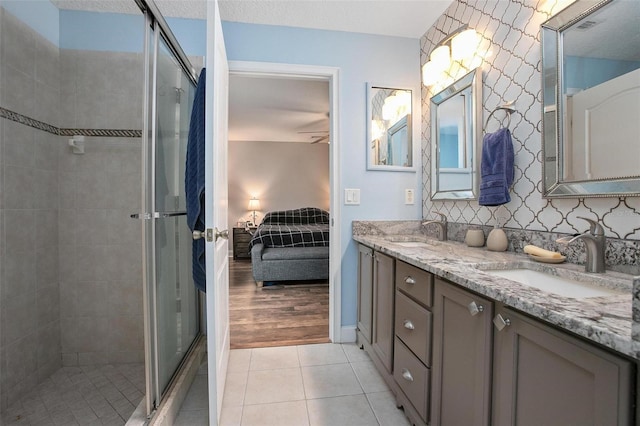 bathroom featuring vanity, an enclosed shower, tile patterned floors, and a textured ceiling