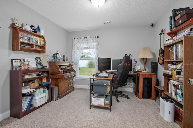 carpeted office space featuring a textured ceiling