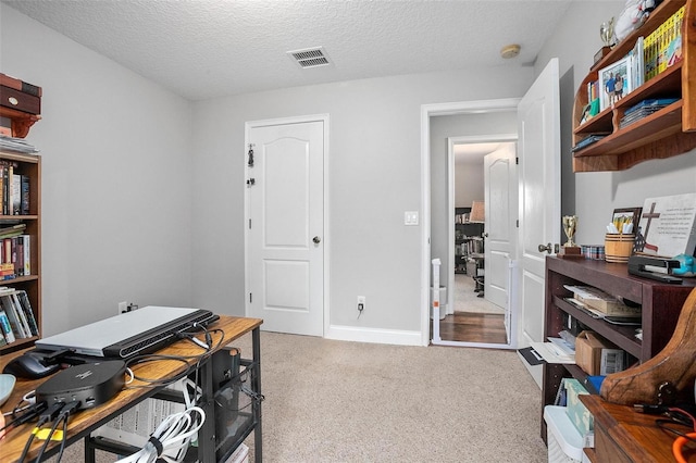 carpeted home office with a textured ceiling