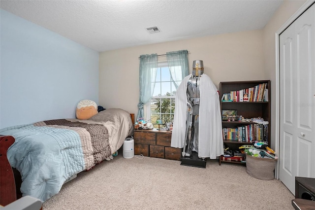 bedroom featuring carpet flooring and a textured ceiling