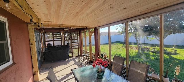 sunroom / solarium with wood ceiling, a wealth of natural light, and a water view