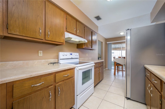 kitchen with stainless steel fridge, light tile patterned floors, and white range with electric stovetop