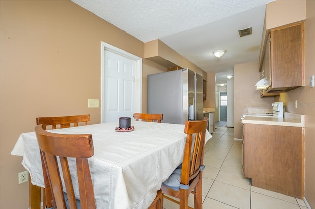 tiled dining space featuring a textured ceiling