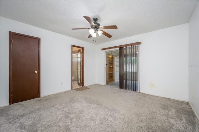 unfurnished room with ceiling fan, light carpet, and a textured ceiling