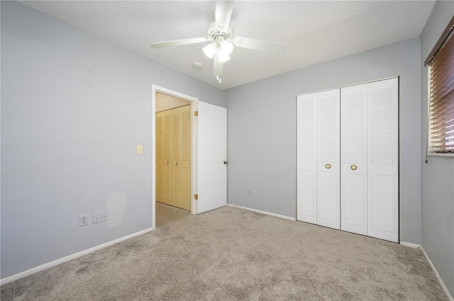 unfurnished bedroom featuring ceiling fan, light carpet, a textured ceiling, and a closet