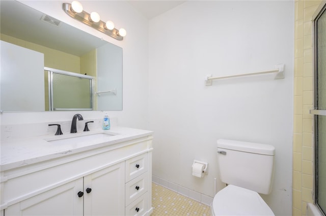 bathroom featuring vanity, toilet, and a shower with shower door